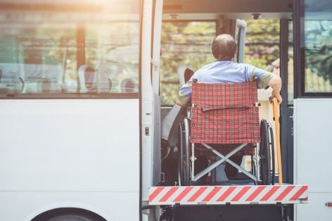 man in wheelchair loading on to charter bus